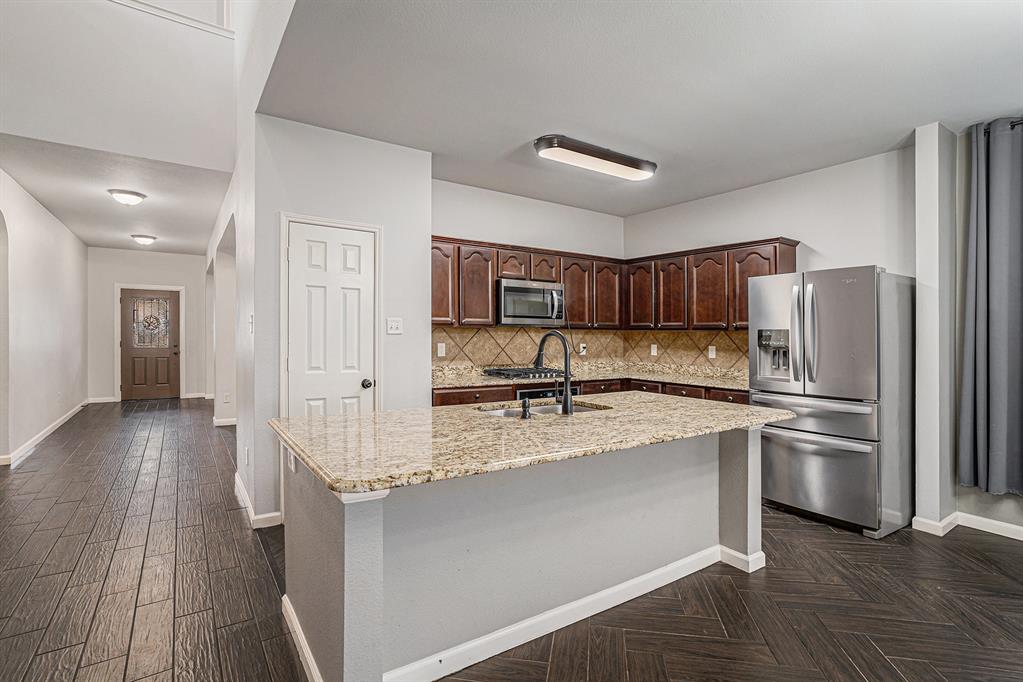 10005 Shelburne Road Fort Worth, TX 76244 - Photo 8 of 26 a kitchen with stainless steel appliances granite countertop a refrigerator a sink dishwasher a stove with wooden floors