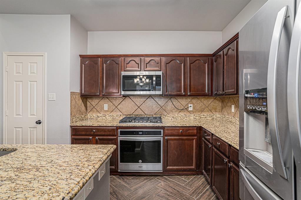 10005 Shelburne Road Fort Worth, TX 76244 - Photo 9 of 26 a kitchen with stainless steel appliances granite countertop a stove and a refrigerator