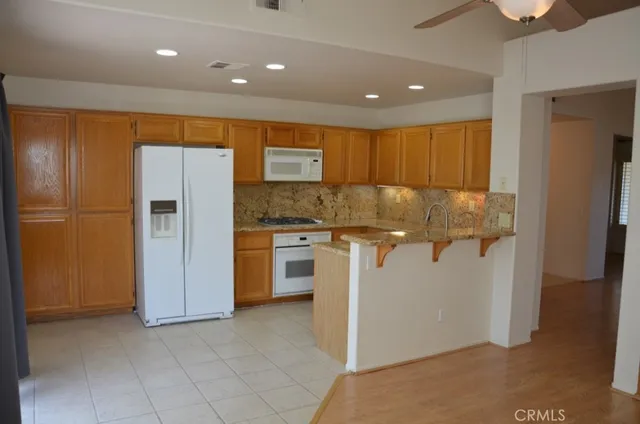a kitchen with stainless steel appliances granite countertop a refrigerator and a stove