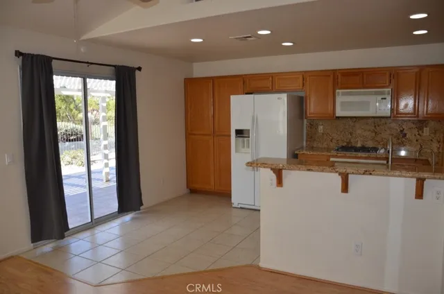 a view of a kitchen with kitchen island a counter top space and stainless steel appliances