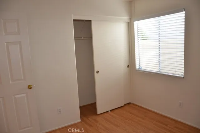 an empty room with wooden floor and a window