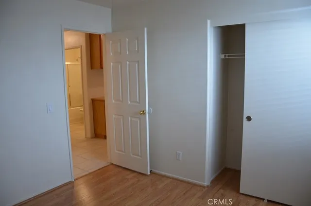 an empty room with wooden floor and closet