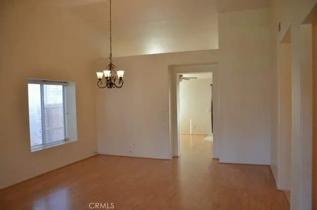 a view of a chandelier in big room with windows and chandelier
