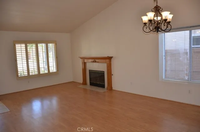 a view of an empty room with a window and fireplace
