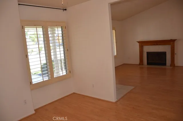 an empty room with windows and fireplace