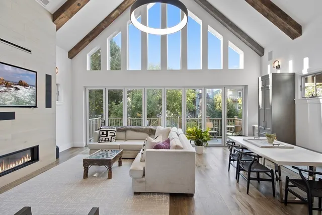 a living room with furniture a fireplace and a large window