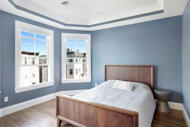 a bedroom with a bed and wooden floor