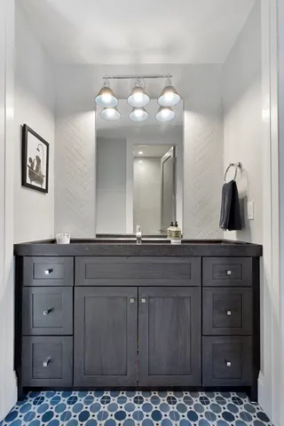 a bathroom with a sink vanity and mirror