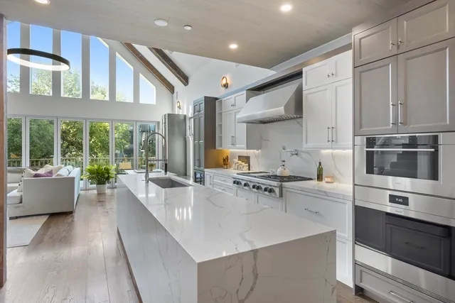 a large kitchen with stainless steel appliances and a large window