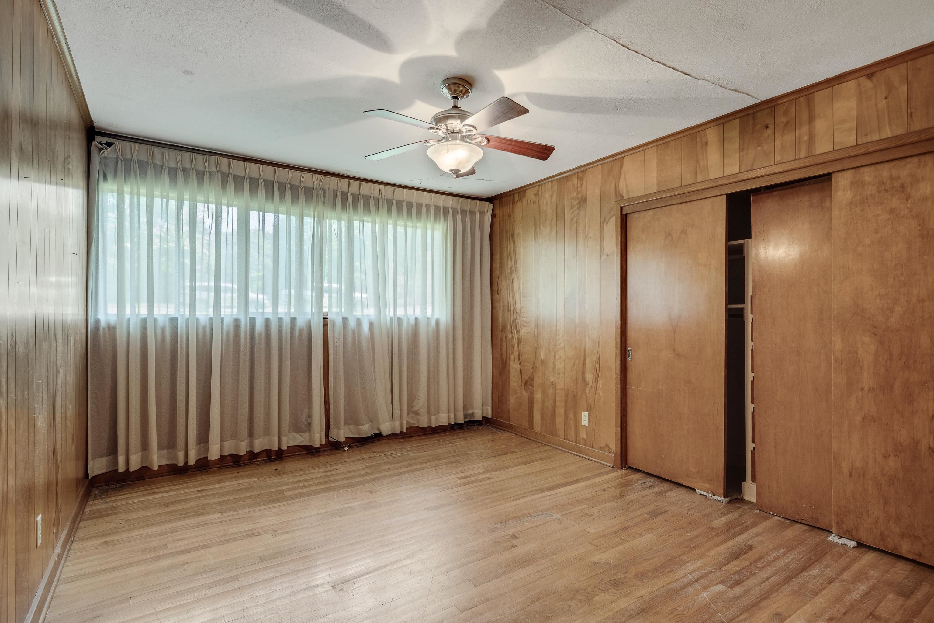 4356 Tuckahoe Road Memphis, TN 38117 - Photo 12 of 25 an empty room with wooden floor fan and windows
