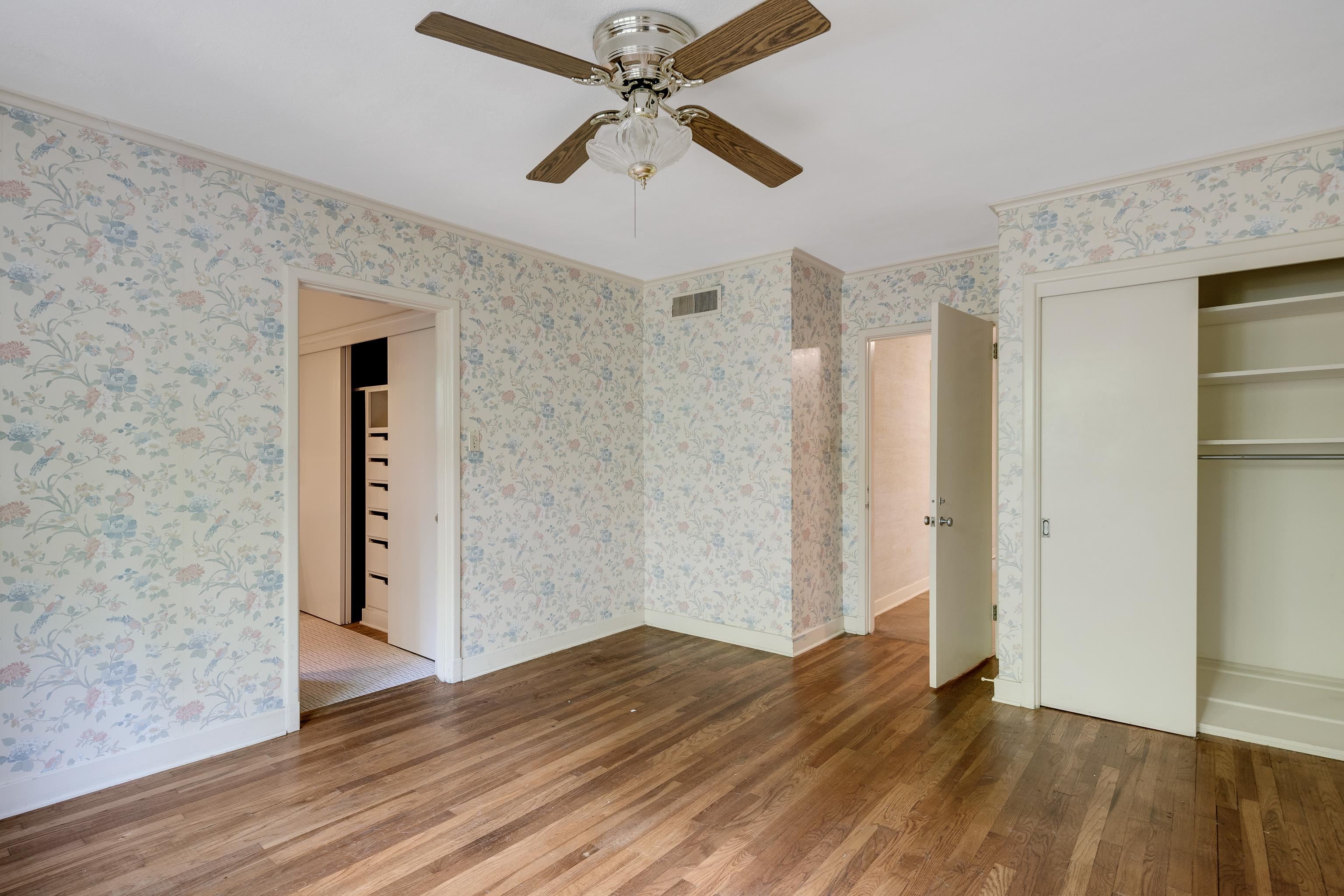 4356 Tuckahoe Road Memphis, TN 38117 - Photo 15 of 25 a view of an empty room with wooden floor and a ceiling fan