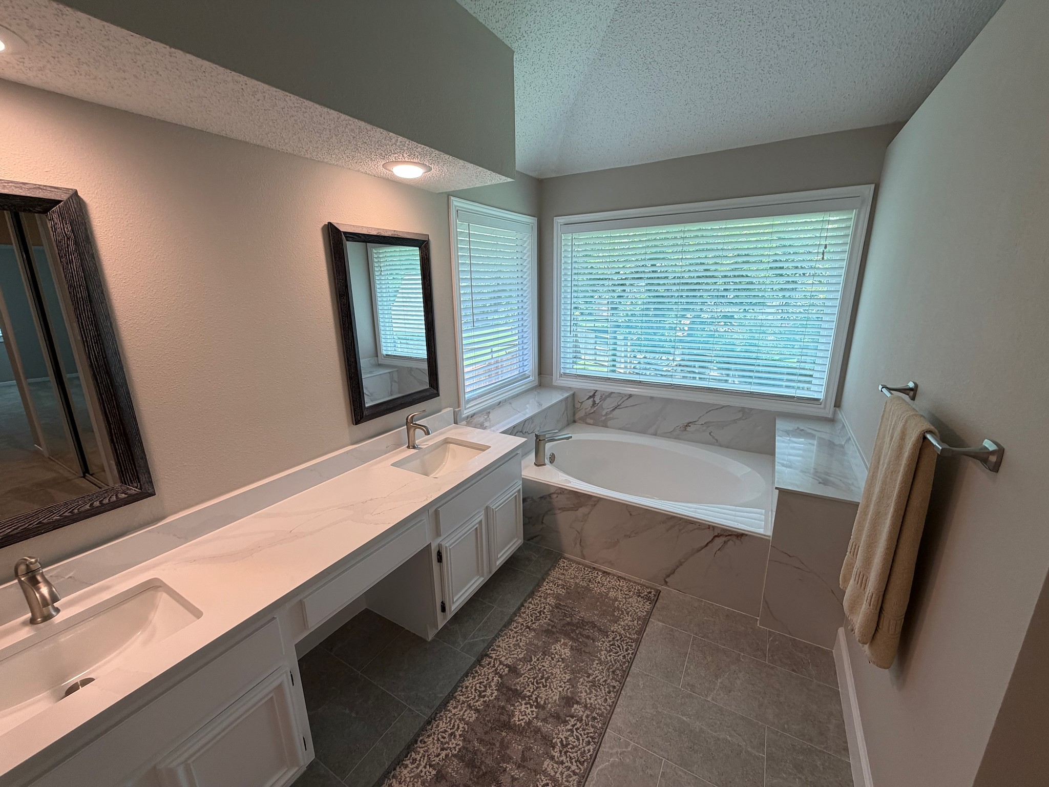 2326 Streamcrest Lane Sugar Land, TX 77479 - Photo 27 of 42 Primary bathroom with large soaking tub, dual sink vanity, tile flooring, and shower with Quartz walls.