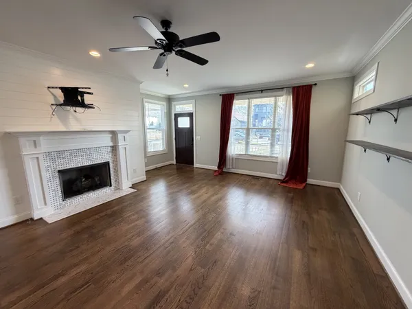 a view of a livingroom with wooden floor and a fireplace
