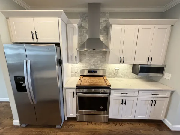 a kitchen with white cabinets and stainless steel appliances