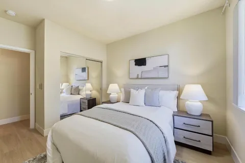 a bedroom with a bed and a painting on the wall