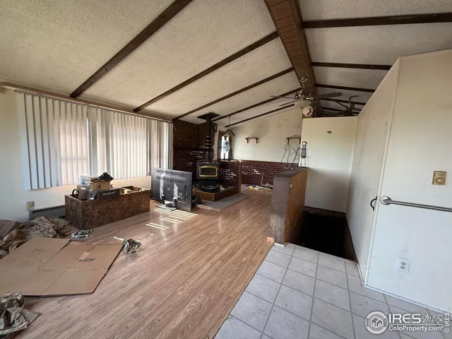 a living room with furniture and a refrigerator