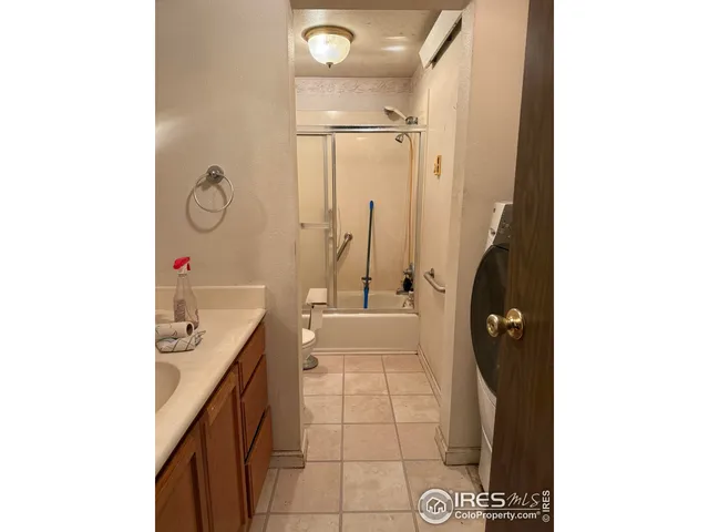 a bathroom with a granite countertop sink a toilet and shower