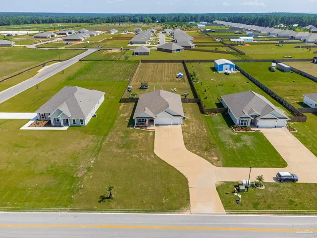 an aerial view of a residential houses with outdoor space