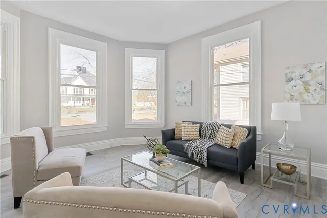 a living room with furniture a fireplace and a large window