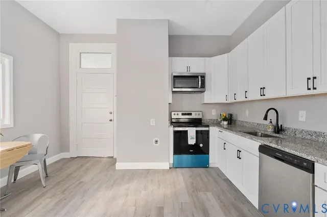 a kitchen with stainless steel appliances granite countertop a stove and a white cabinets