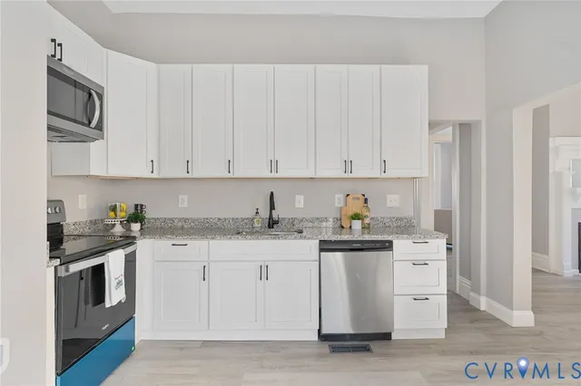 a kitchen with granite countertop white cabinets and sink
