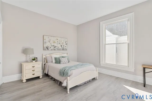 a bedroom with a bed and large windows