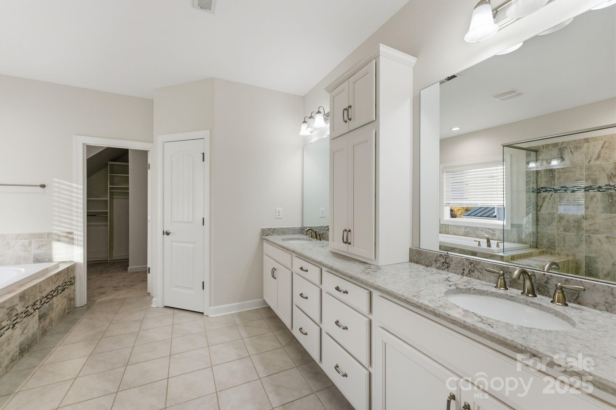 374 Hampton Trail Drive Fort Mill, SC 29708 - Photo 34 of 48 a spacious bathroom with a granite countertop double vanity sink a mirror and a bathtub