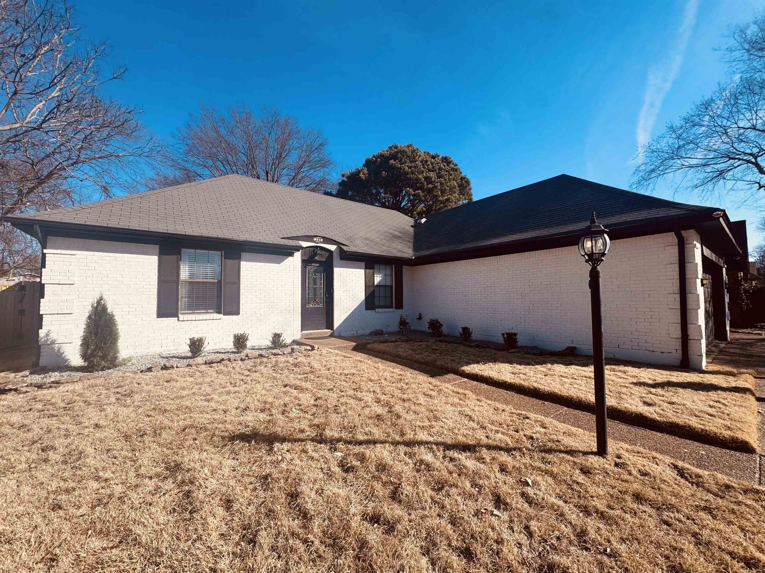 View of front of property with brick siding and a front yard