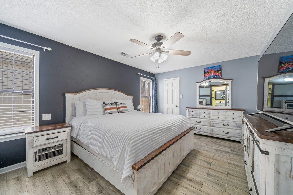 6310 Prairie View Drive Bartlett, TN 38134 - Photo 15 of 27 a bedroom with a bed and a dresser with wooden floor