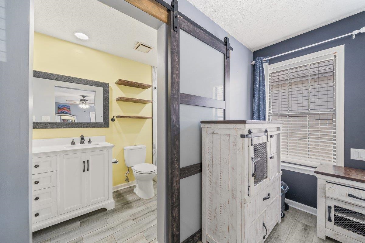6310 Prairie View Drive Bartlett, TN 38134 - Photo 16 of 27 a bathroom with a toilet a sink a vanity and a window