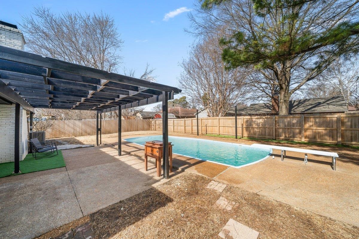 6310 Prairie View Drive Bartlett, TN 38134 - Photo 23 of 27 View of swimming pool featuring a pergola, patio surround, a diving board, and a fenced backyard