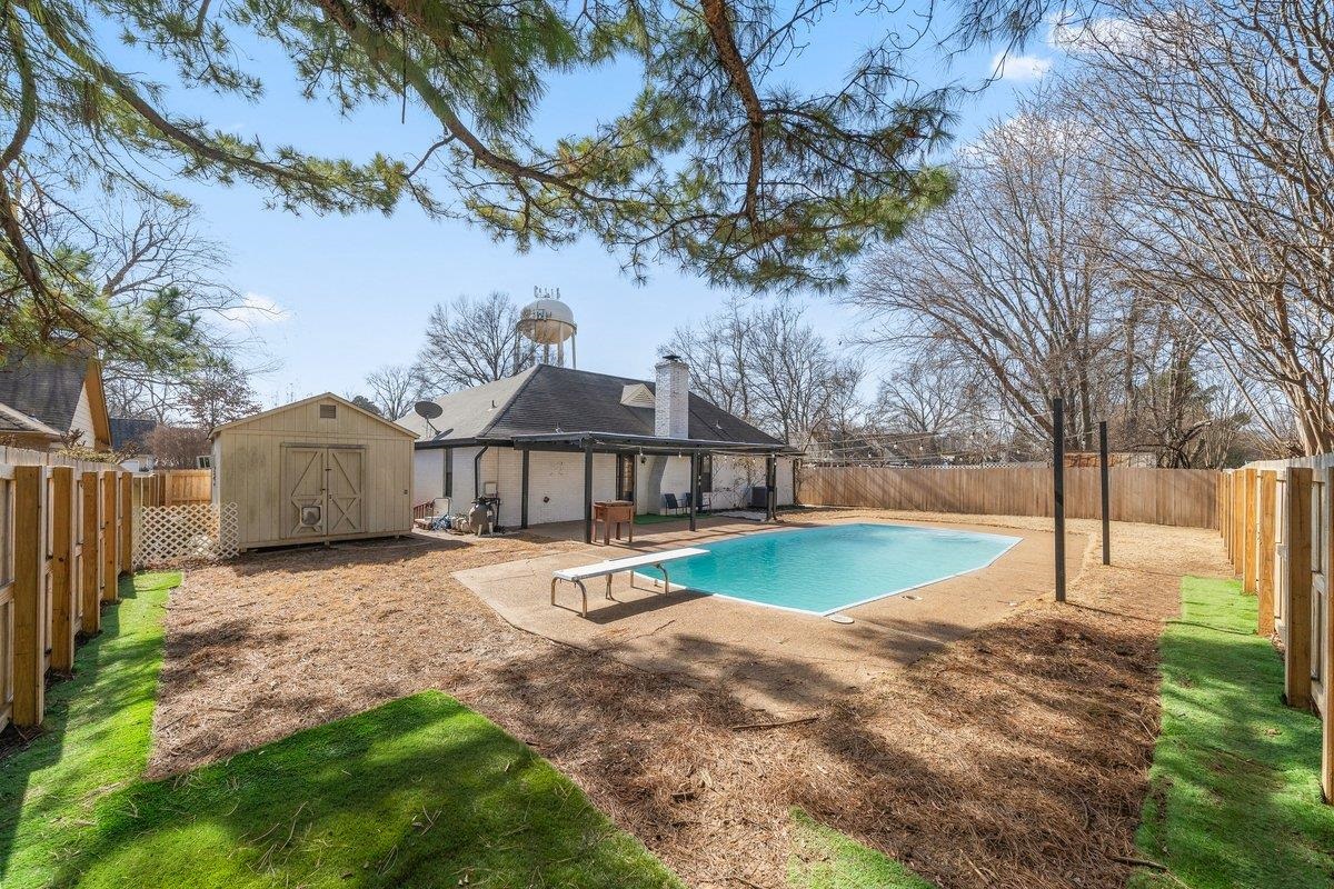 6310 Prairie View Drive Bartlett, TN 38134 - Photo 24 of 27 View of pool with patio surround, a fenced backyard, a diving board, and a storage shed