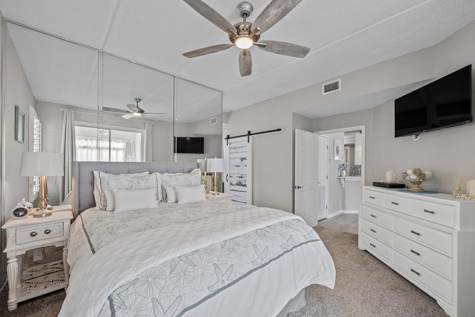 500 Augusta Circle St. Augustine, FL 32086 - Photo 18 of 39 a bedroom with a large bed a flat tv screen and a ceiling fan