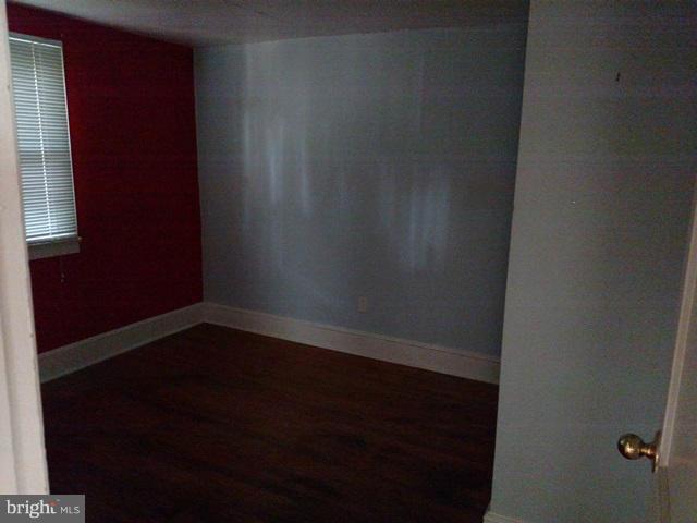 6173 Bethlehem Road Preston, MD 21655 - Photo 5 of 8 a view of an empty room with wooden floor and a window