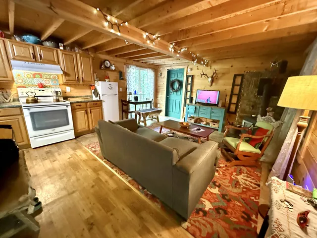 a living room with stainless steel appliances kitchen island granite countertop a sink and cabinets