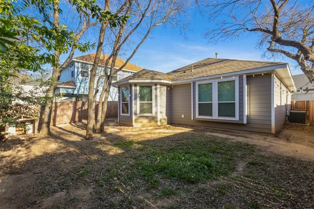 a view of a yard in front of a house with large trees