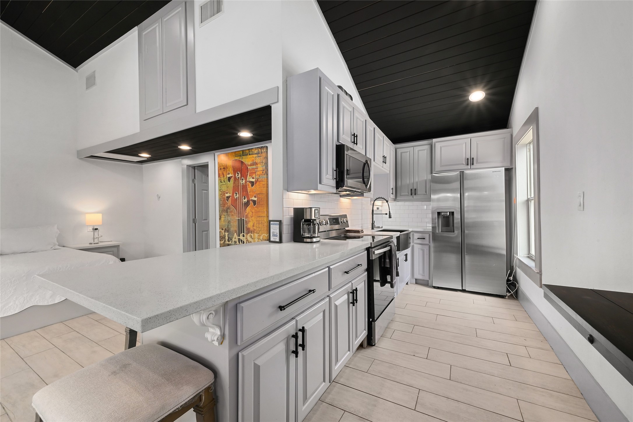 2903 Oak Ridge Drive Spicewood, TX 78669 - Photo 21 of 33 GUEST HOUSE-Kitchen featuring stainless steel appliances, backsplash, light stone counters, and a breakfast bar.