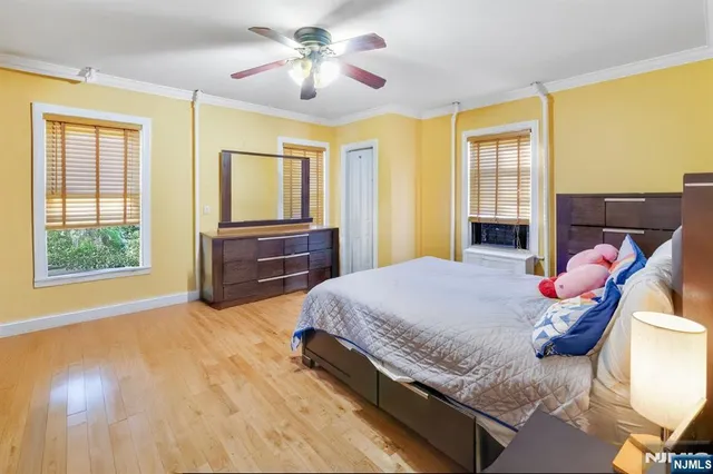 a spacious bedroom with a bed and wooden floor