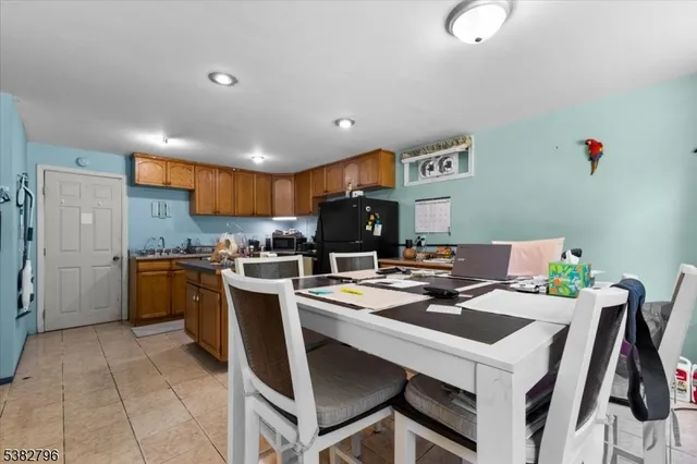 a kitchen with a dining table chairs and refrigerator