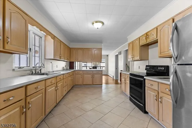 a kitchen with stainless steel appliances sink cabinets and window