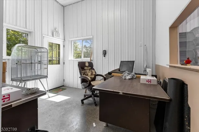 a view of a workspace with furniture and a window