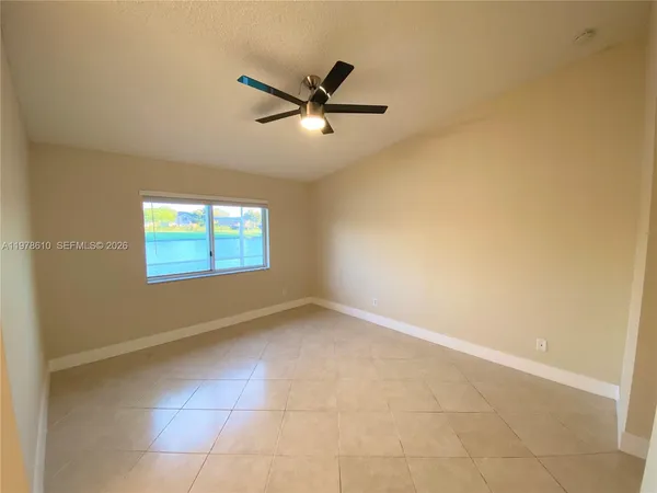 an empty room with closet and a ceiling fan
