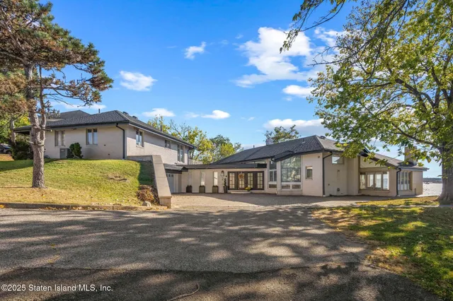 a view of a house with a big yard and large tree