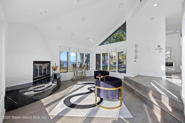 a living room with furniture a flat screen tv and a large window
