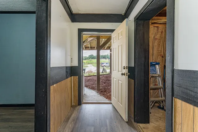 an empty room with wooden floor cabinet and windows