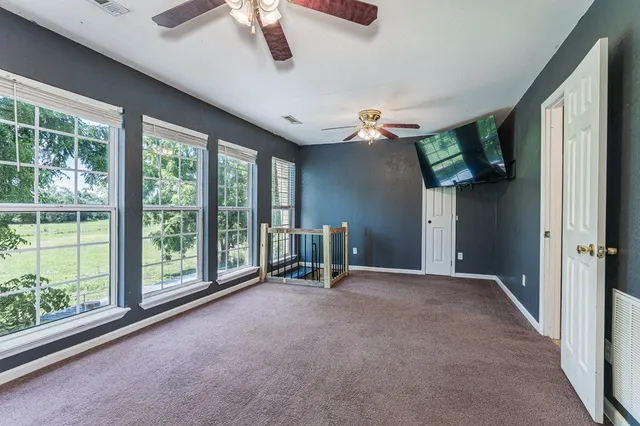 a view of a livingroom with a chandelier fan and a kitchen