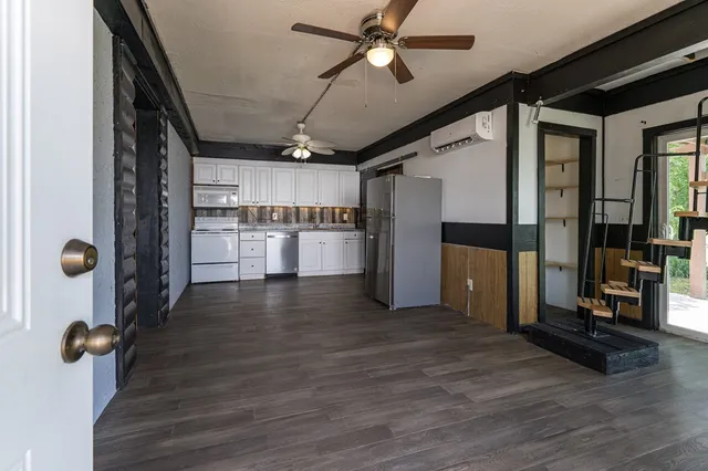 a view of a kitchen with a refrigerator and a wooden floor