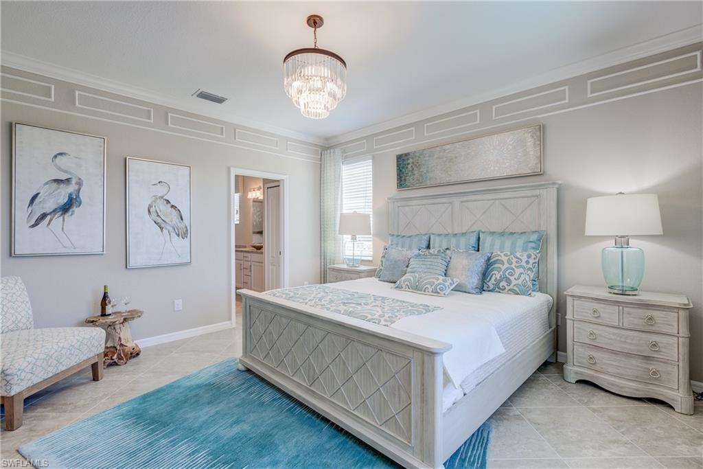 2595 Scarlet Way Naples, FL 34120 - Photo 14 of 27 a bedroom with a large bed and a chandelier