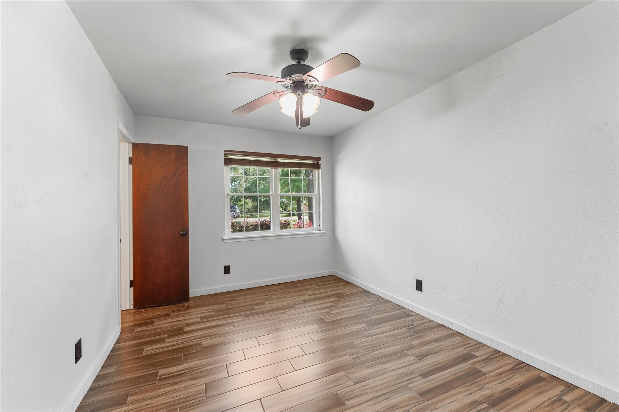 326 Broad Ripple Drive Houston, TX 77336 - Photo 12 of 26 an empty room with wooden floor chandelier fan and windows