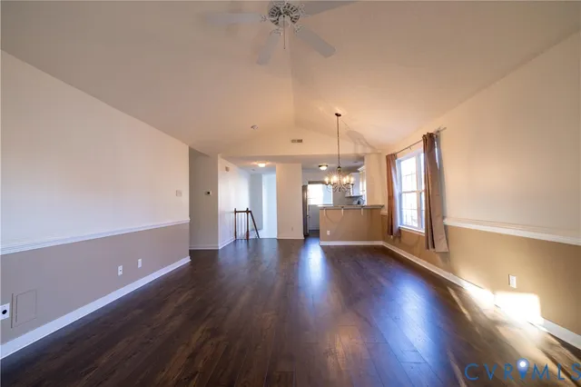 an empty room with wooden floor and a ceiling fan